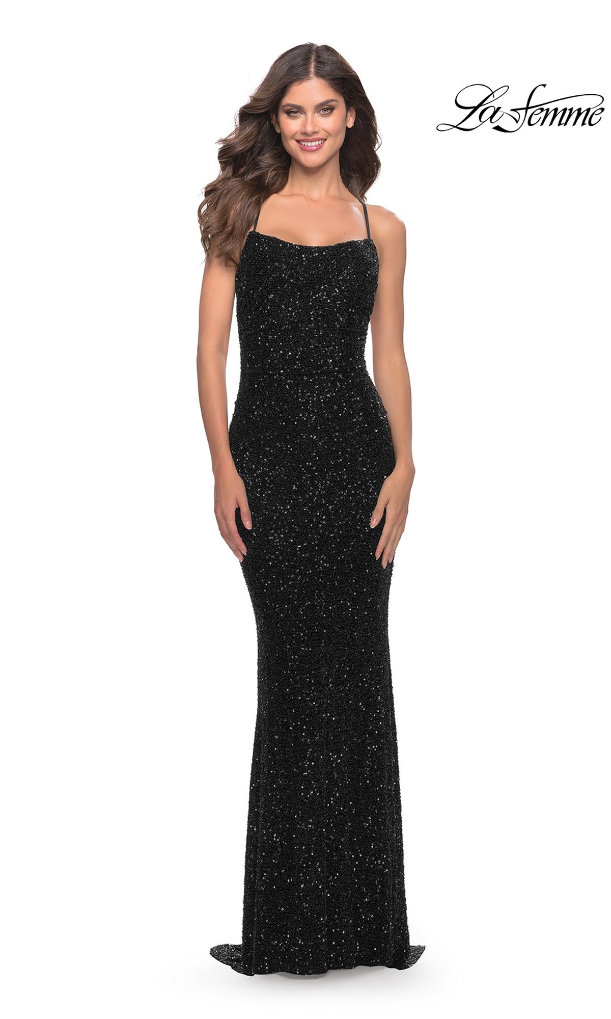 A woman smiles in an Open-Back La Femme Long Sequin Prom Dress 31027—black, floor-length with thin straps—posing against a plain white background. The